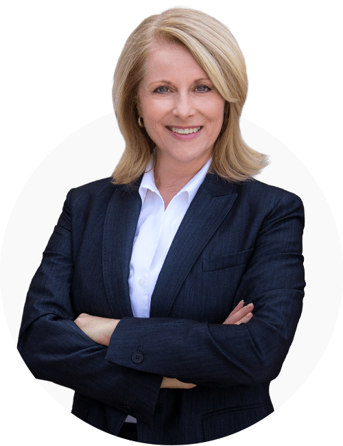 Older professional looking woman, smiling with her arms crossed, looking into the camera.