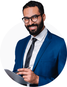 A photo of a professional looking man in a blazer, smiling at the camera with a tablet in his hand.