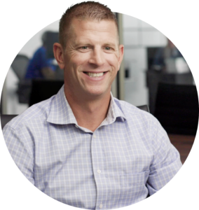 A photo of a professional looking man, smiling at the camera.